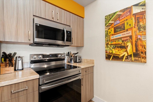 kitchen featuring stainless steel appliances and light brown cabinetry