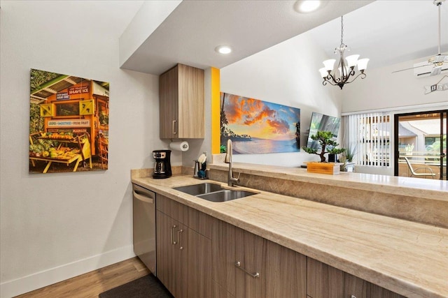 kitchen with an inviting chandelier, decorative light fixtures, dishwasher, wood-type flooring, and sink