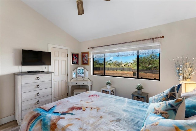 bedroom with ceiling fan, lofted ceiling, and hardwood / wood-style floors