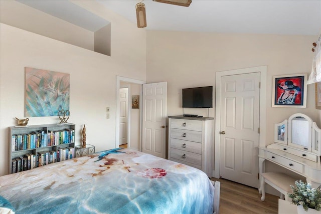 bedroom featuring light wood-type flooring, ceiling fan, and vaulted ceiling