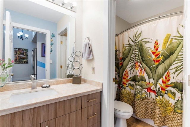 bathroom with toilet, hardwood / wood-style floors, and vanity