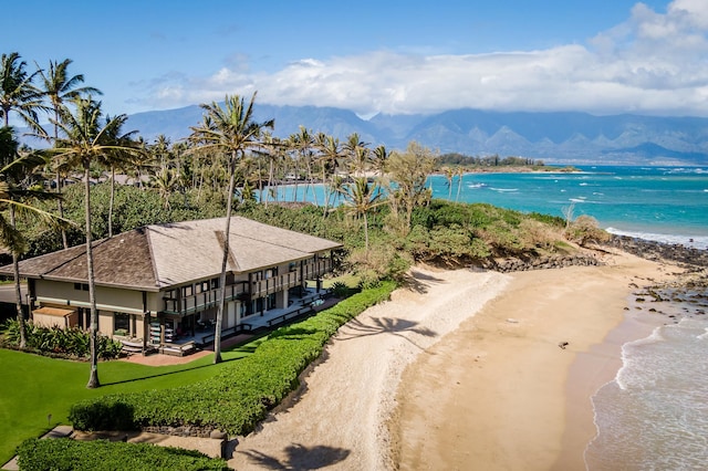 birds eye view of property with a water and mountain view and a view of the beach