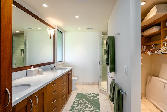 bathroom with toilet, vanity, tile patterned floors, and a shower with door