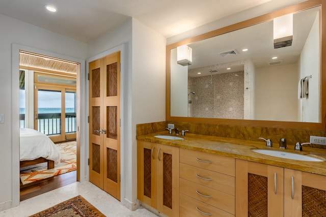 bathroom with french doors, vanity, tiled shower, wood-type flooring, and a water view