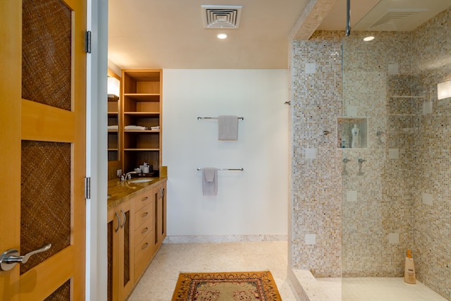 bathroom with vanity and tiled shower