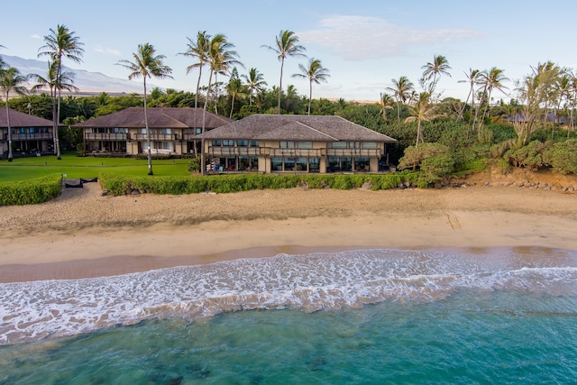 back of property featuring a view of the beach and a water view