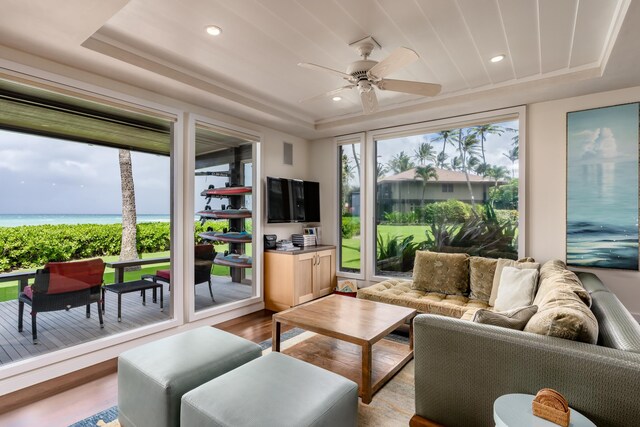 sunroom / solarium with a tray ceiling and ceiling fan