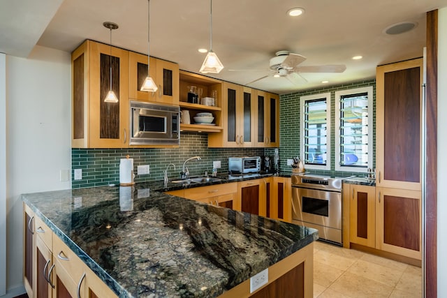 kitchen with decorative light fixtures, sink, appliances with stainless steel finishes, and dark stone counters