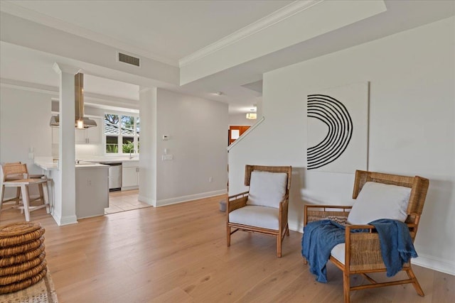 sitting room featuring light hardwood / wood-style flooring and ornamental molding