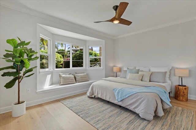 bedroom featuring light hardwood / wood-style floors, ceiling fan, and ornamental molding