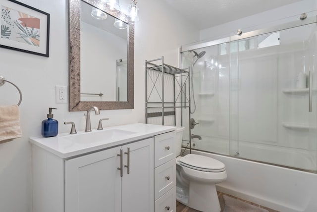 bathroom with combined bath / shower with glass door, toilet, and vanity