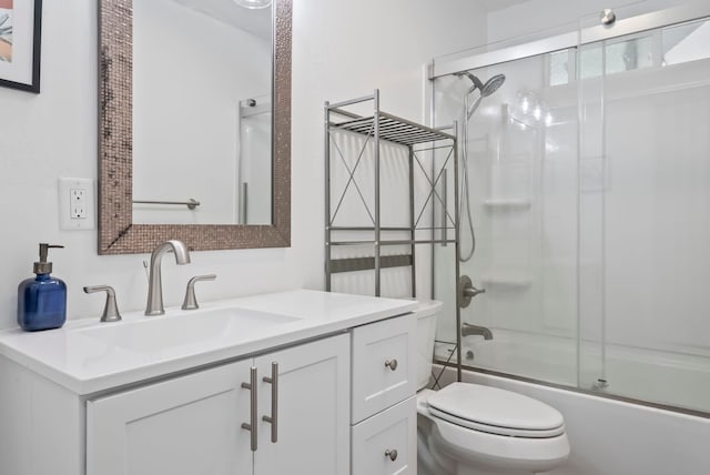 bathroom with toilet, vanity, and bath / shower combo with glass door
