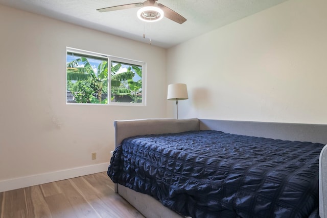 bedroom with baseboards, wood finished floors, and a ceiling fan