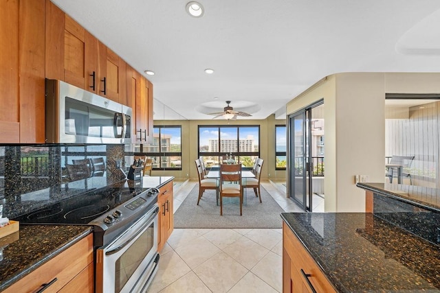 kitchen with brown cabinets, light tile patterned flooring, ceiling fan, appliances with stainless steel finishes, and recessed lighting