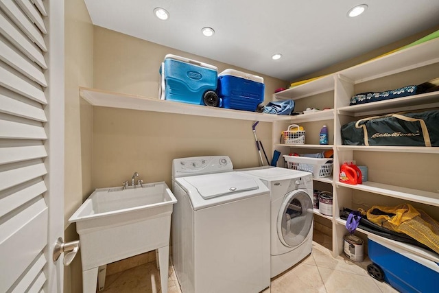 laundry area with laundry area, recessed lighting, washer and clothes dryer, a sink, and light tile patterned floors