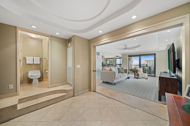 ensuite bathroom with toilet, recessed lighting, tile patterned floors, a tray ceiling, and ensuite bath