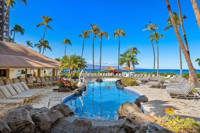 community pool featuring a patio and a water view