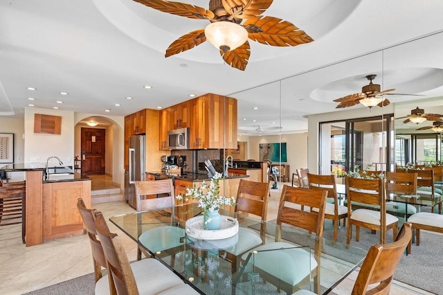 dining space featuring a ceiling fan, arched walkways, and recessed lighting