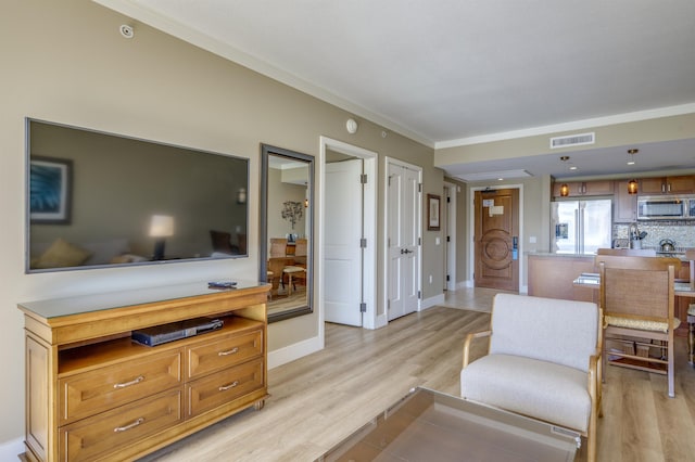 living room featuring light wood-type flooring and ornamental molding