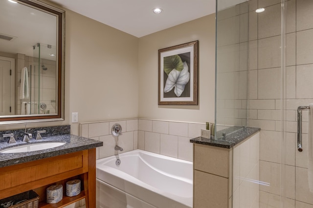 bathroom featuring vanity and independent shower and bath