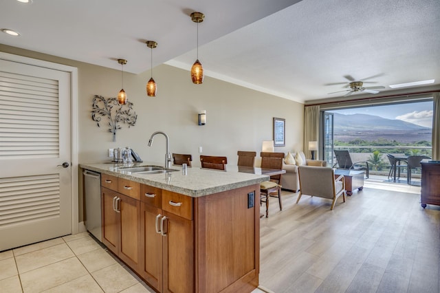 kitchen with sink, stainless steel dishwasher, ceiling fan, decorative light fixtures, and kitchen peninsula