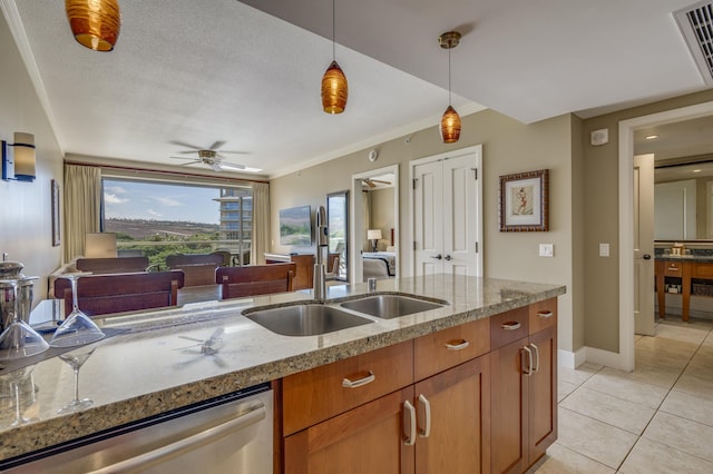 kitchen featuring sink, dishwasher, light stone counters, and hanging light fixtures