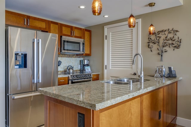 kitchen featuring light stone countertops, sink, backsplash, decorative light fixtures, and appliances with stainless steel finishes