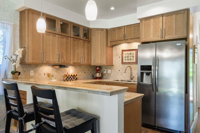4435 Lower Honoapiilani Rd Unit 152, Lahaina, HI 96761 - kitchen featuring stainless steel fridge with ice dispenser, a sink, a breakfast bar, light countertops, and glass insert cabinets