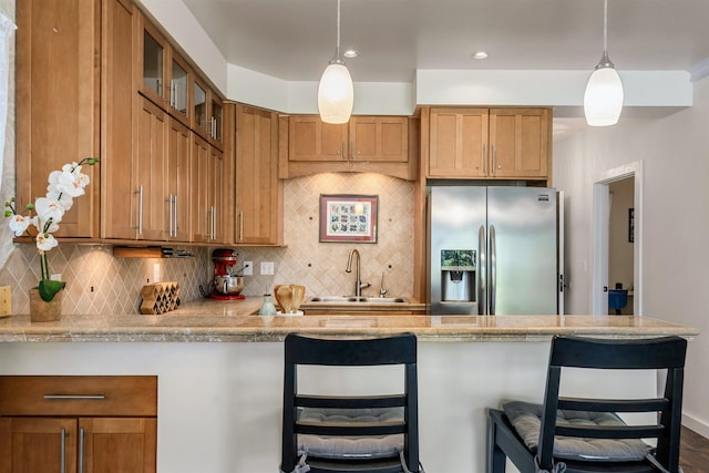 4435 Lower Honoapiilani Rd Unit 152, Lahaina, HI 96761 - kitchen with stainless steel fridge with ice dispenser, a sink, light countertops, a breakfast bar, and glass insert cabinets