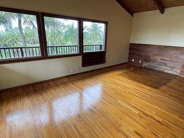 spare room with wood ceiling, lofted ceiling with beams, and light hardwood / wood-style flooring