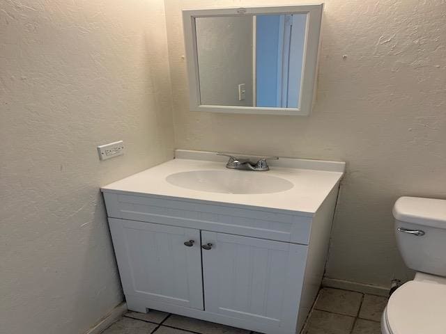 bathroom featuring tile patterned floors, vanity, and toilet