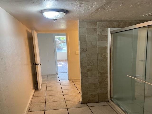 bathroom with tile patterned flooring and a shower with shower door