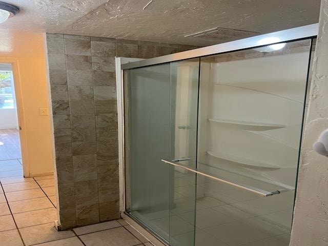 bathroom featuring tile patterned floors and a shower with shower door