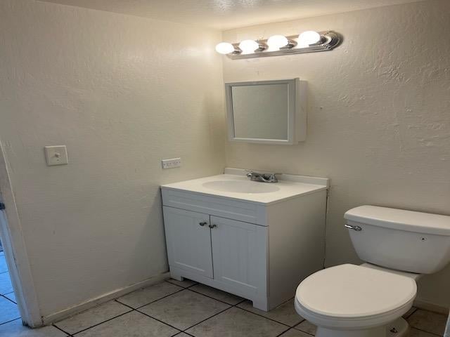 bathroom featuring tile patterned flooring, vanity, and toilet