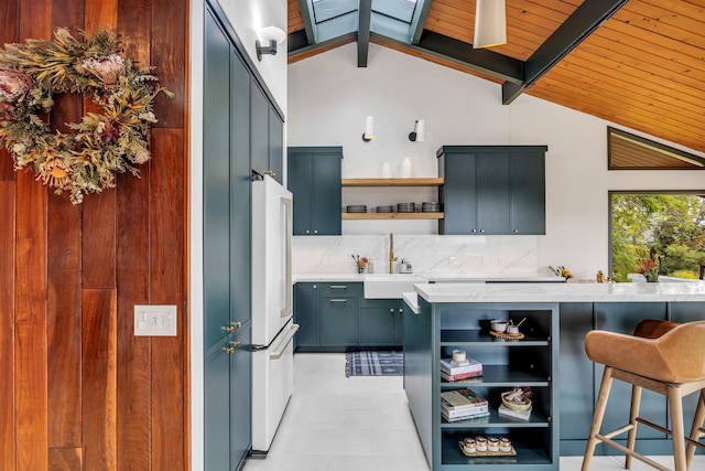 kitchen with freestanding refrigerator, open shelves, a sink, vaulted ceiling with beams, and backsplash