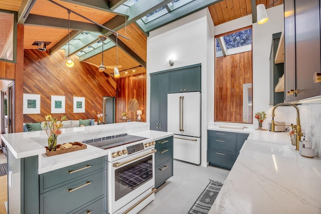 kitchen with white appliances, a skylight, wood walls, a sink, and open floor plan