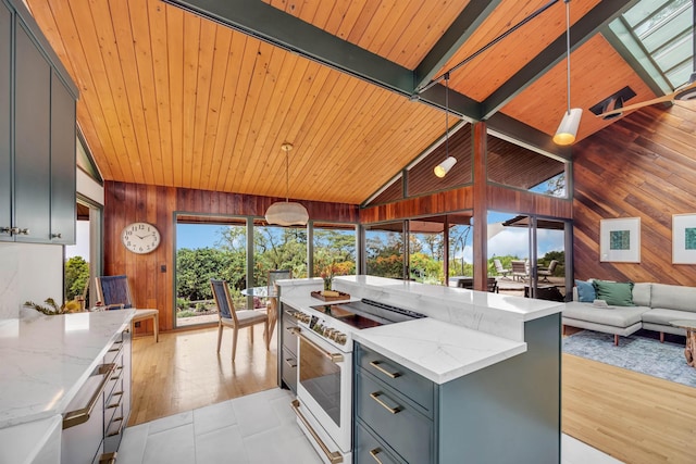 kitchen featuring gray cabinets, wooden walls, a center island, light stone countertops, and white electric range