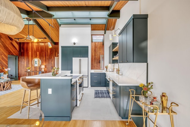 kitchen with open shelves, a sink, light countertops, white appliances, and wood walls