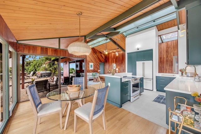 dining room featuring wood walls, light wood-type flooring, wooden ceiling, and lofted ceiling with beams
