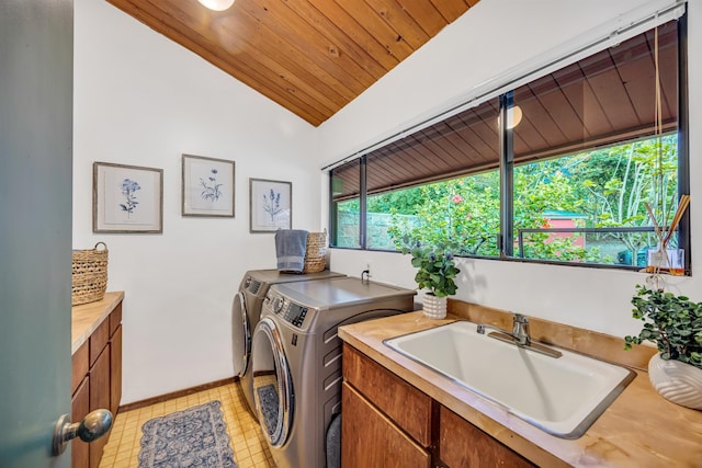 washroom featuring wood ceiling, a sink, washing machine and clothes dryer, and cabinet space