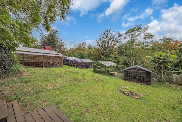 view of yard featuring fence, an outdoor structure, and exterior structure