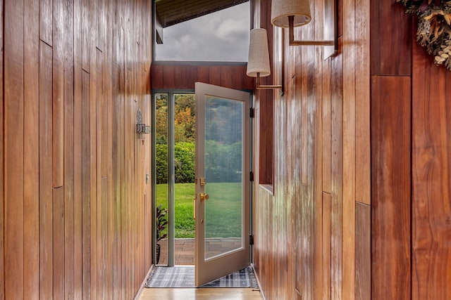 doorway to outside featuring wooden walls