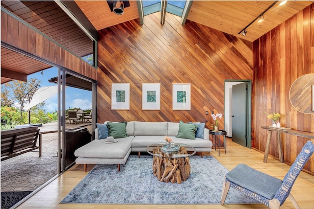 living room with track lighting, wooden ceiling, wood finished floors, and wood walls
