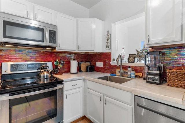 kitchen with white cabinetry, sink, stainless steel appliances, light stone counters, and decorative backsplash