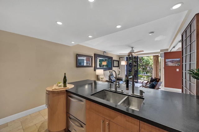 kitchen featuring sink, light tile patterned floors, dishwasher, ceiling fan, and kitchen peninsula