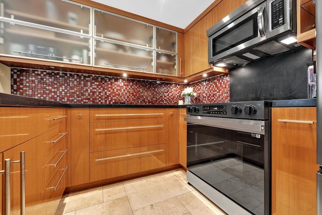 kitchen with stainless steel appliances and decorative backsplash