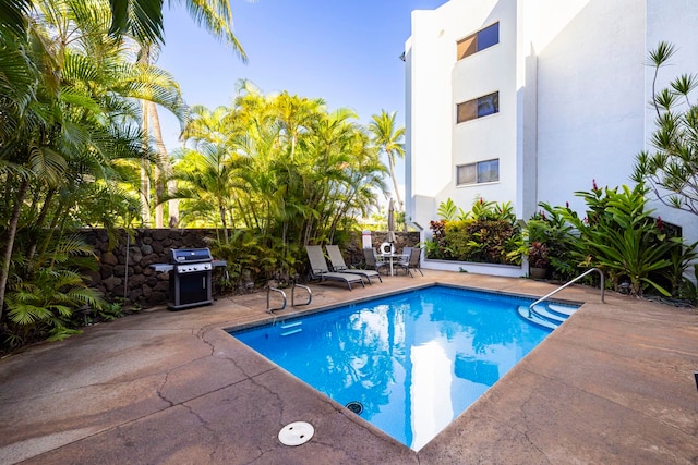 view of swimming pool featuring a grill and a patio area