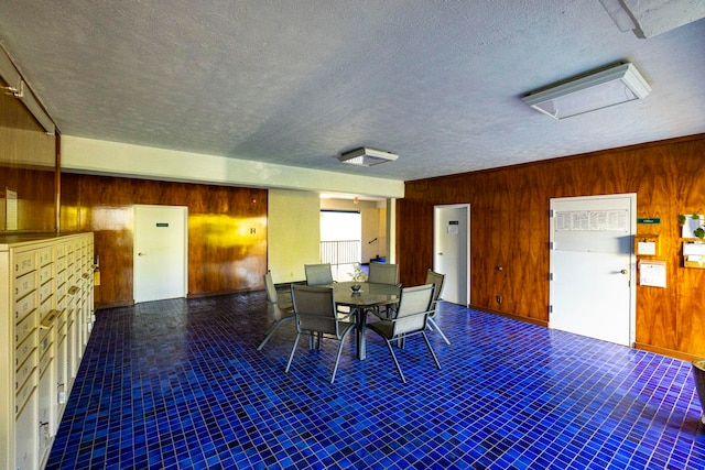 dining area featuring a textured ceiling and wooden walls