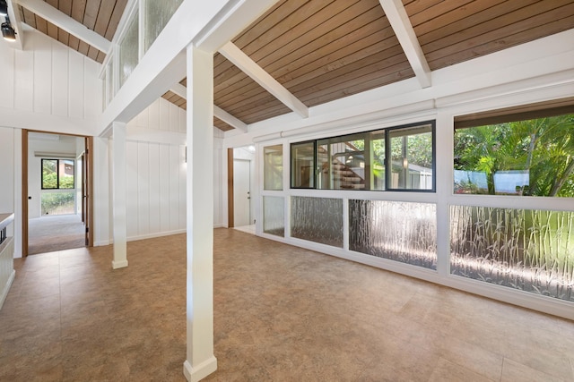 unfurnished sunroom featuring wood ceiling and vaulted ceiling with beams