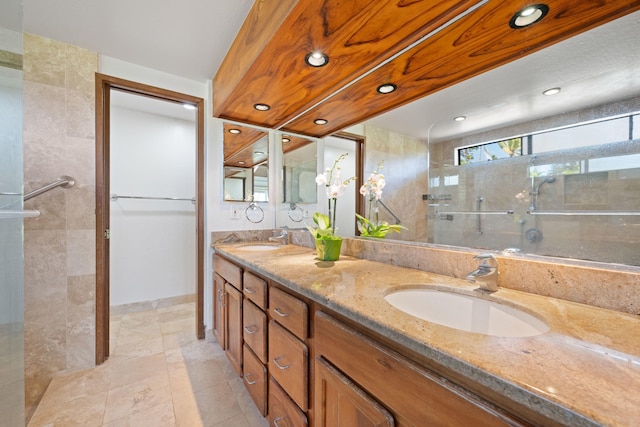 full bath with double vanity, recessed lighting, tiled shower, and a sink